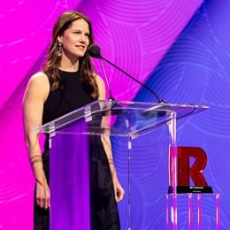 Award presentation at an NRF event, a woman giving a speech on stage next to an NRF Foundation trophy.